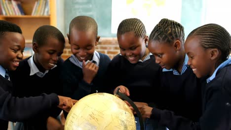 Schoolkids-using-globe-in-classroom-4k