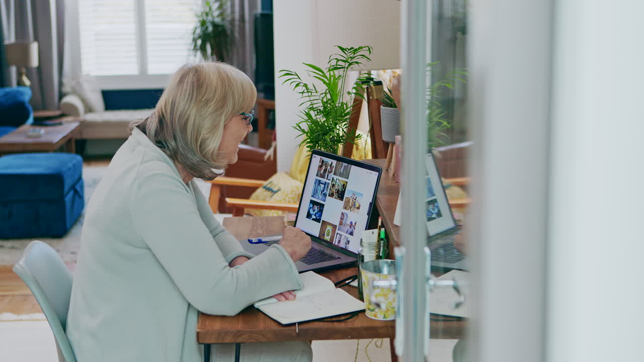 Eldre kvinne jobber på laptop på hjemmekontor
