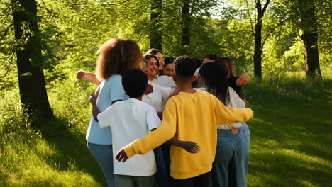 diverse group of young people hugging in a sunny park