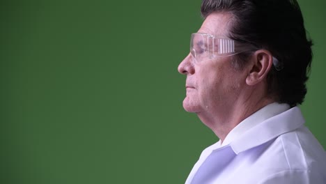 profile view of senior handsome man doctor with protective glasses