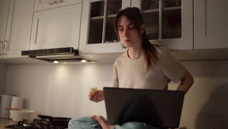 mujer trabajando y comiendo en la cocina
