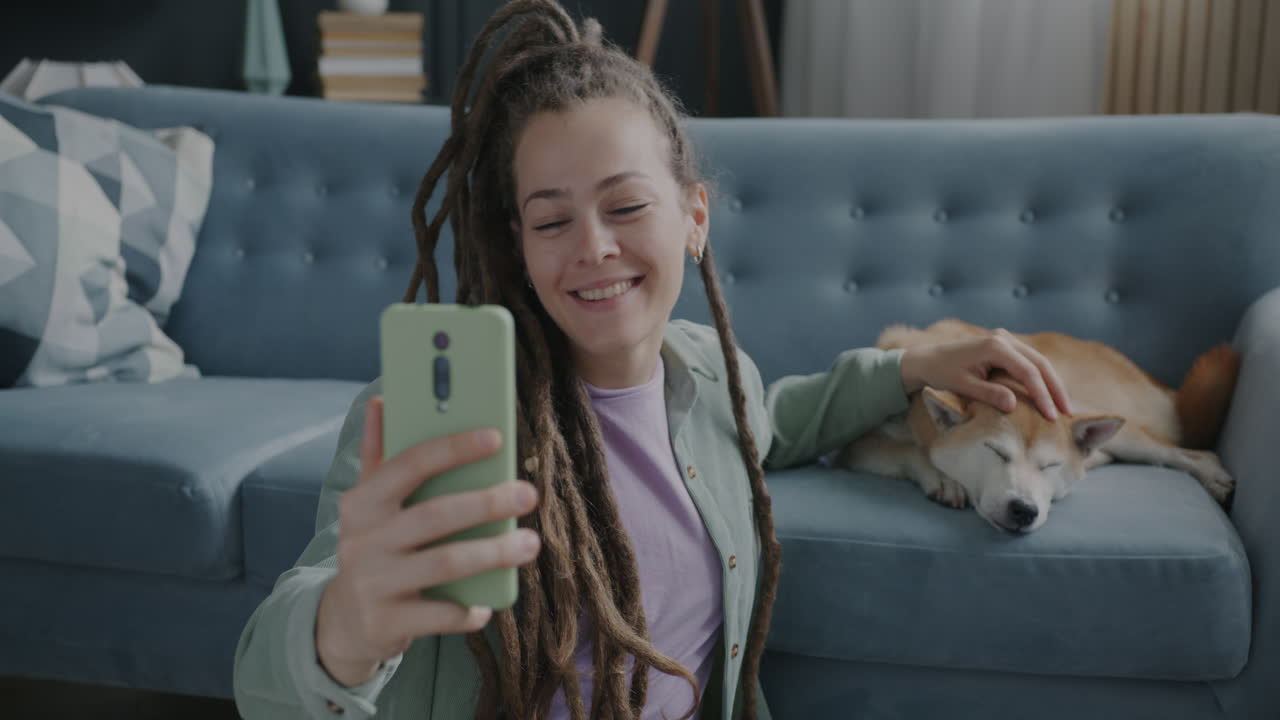 Woman video chatting with her dog at home