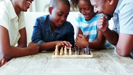 familia jugando al ajedrez juntos en casa en la sala de estar
