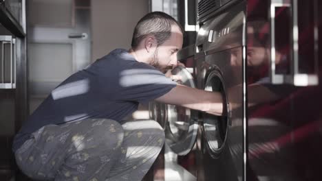 Man-washing-his-clothes-on-the-washing-machine