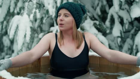 caucasian woman during the winter bath in tube outdoors.