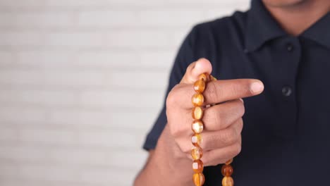 muslim man keep hand in praying gestures during ramadan, close up