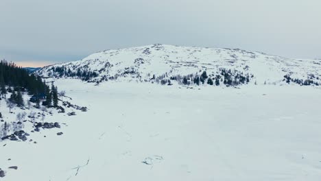 Flying-Over-Snow-covered-Frozen-Lake-At-Winter-In-Verran,-Indre-Fosen,-Norway