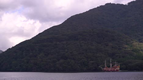 Famous-Hakone-Pirate-ship-floating-fast-on-Lake-Ashi-with-green-mountains-in-background
