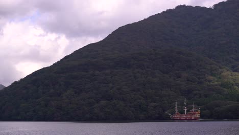 famous hakone pirate ship floating fast on lake ashi with green mountains in background