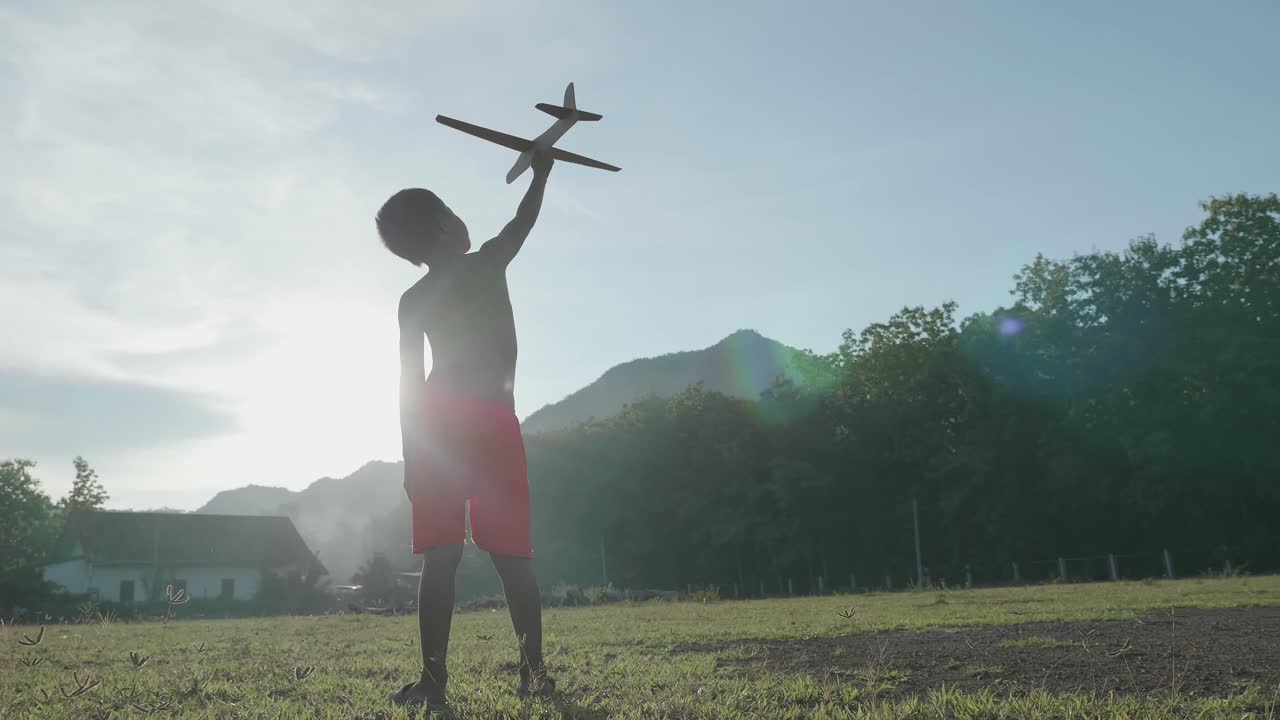 A Boy with a Toy Airplane in the Meadow
