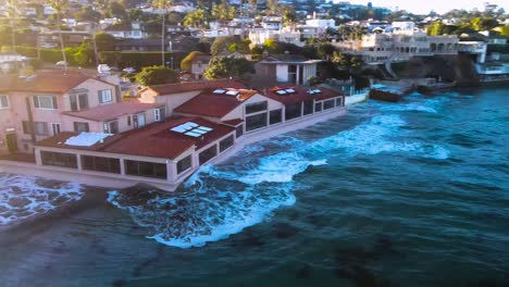 aerial view of la jolla shores at high tide with waves crashing up against a building