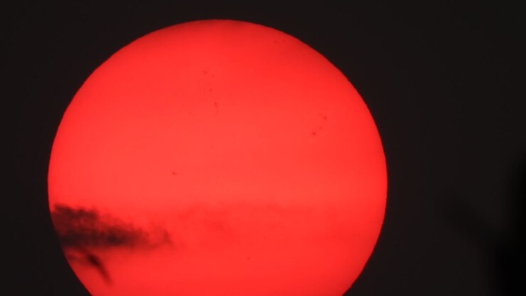 Orange sun close up black clouds