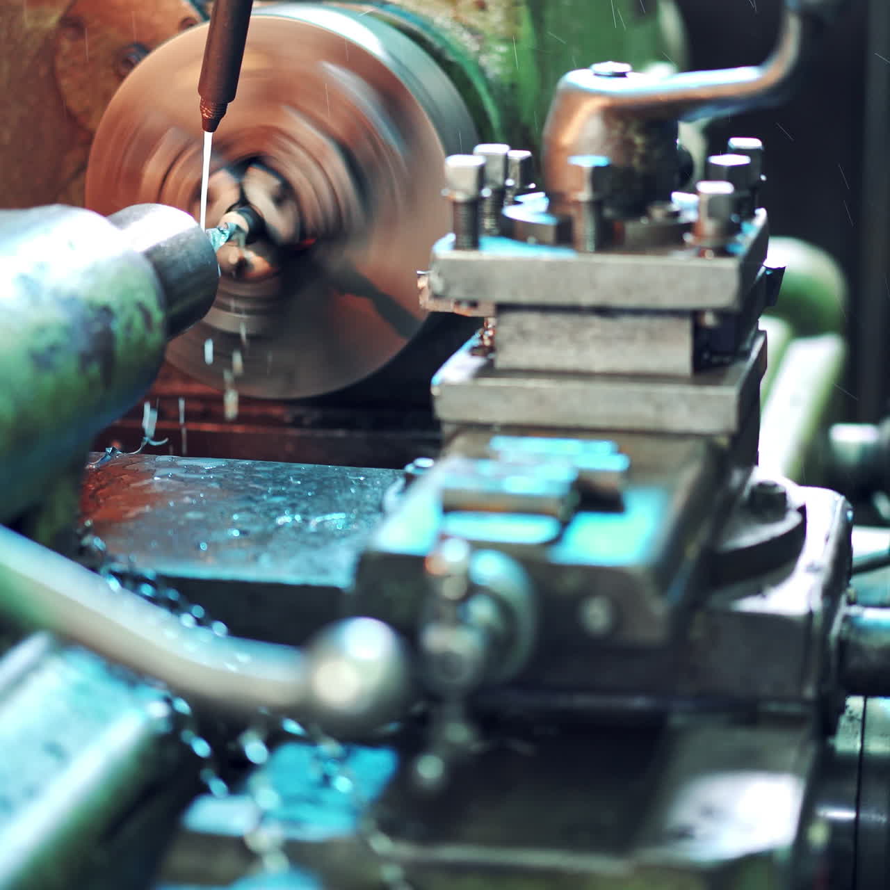 Machine operator turns on an industrial machine. Man employee working with turning lathe and metalworking machine at manufacturing hall at industrial factory