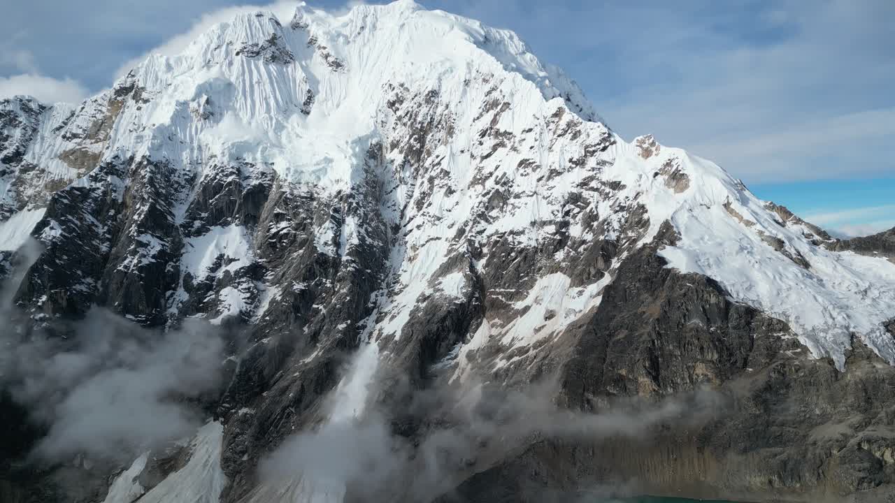 Veduta aerea del Salkantay durante l'ora d'oro, con la luce del sole che illumina le cime frastagliate e le nuvole in movimento
