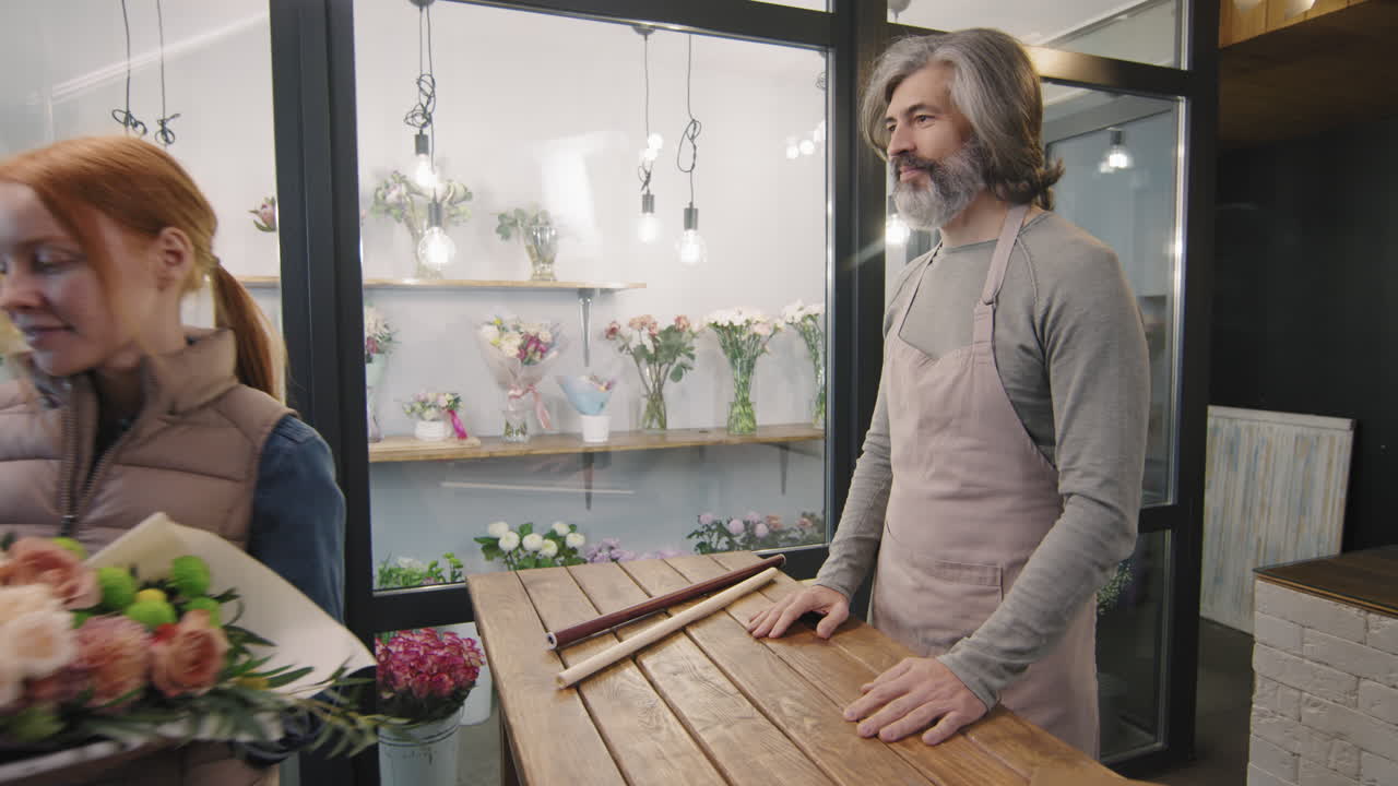 Floristka předávající kytici zákazníkovi