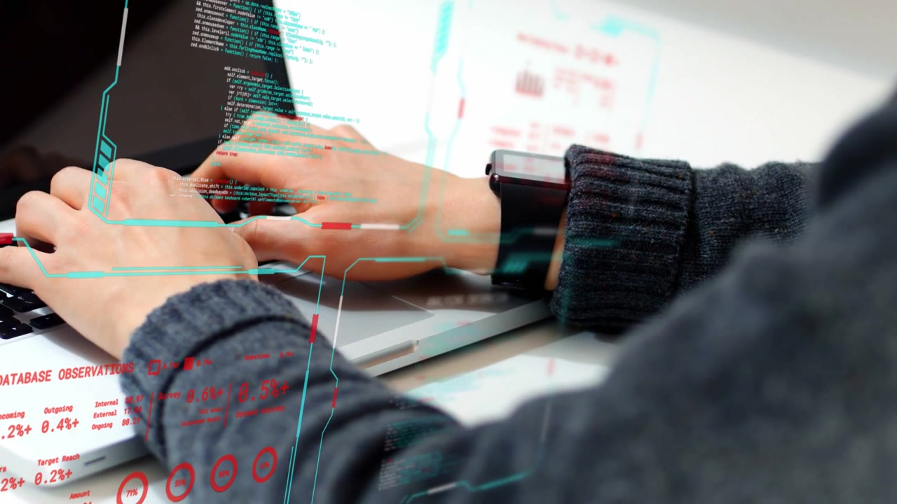 Developer hands typing on laptop keys at desk, HUD graphics syncing with motion while writing code