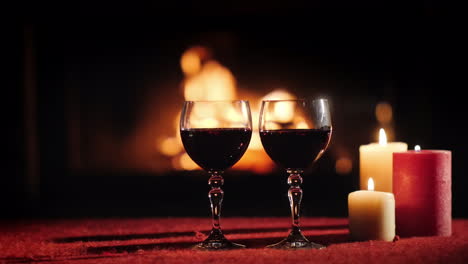 Two-Glasses-With-Red-Wine-Against-The-Background-Of-The-Fireplace-Where-The-Fire-Is-Burning
