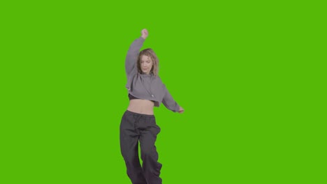 studio shot of young woman having fun dancing against green screen 35