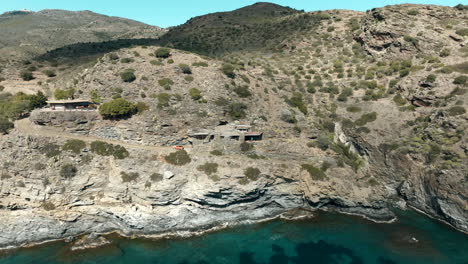 luxury house on rocky cliff near lake water in spain, aerial drone view