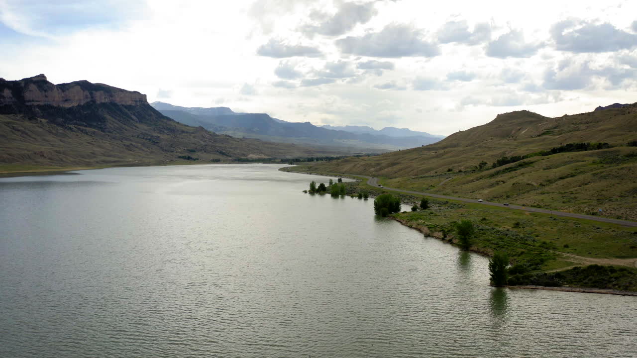 Scenic landscape of a lake surrounded by mountains with a road alongside