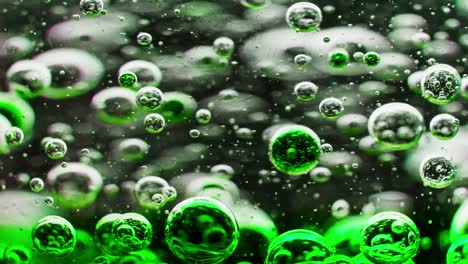 macro shot of green bubbles slowly sinking in water