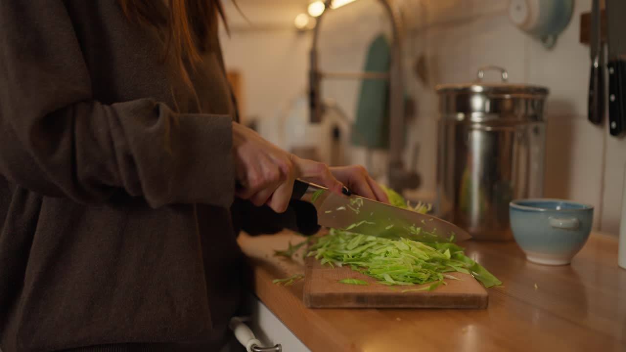 Woman cutting cabbage in kitchen