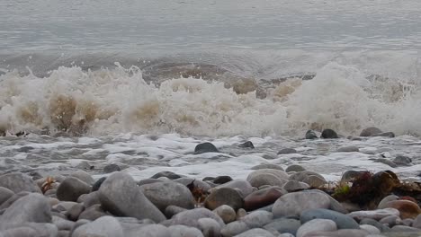 foaming white waves washing into calming serene rocky pebble stone shoreline