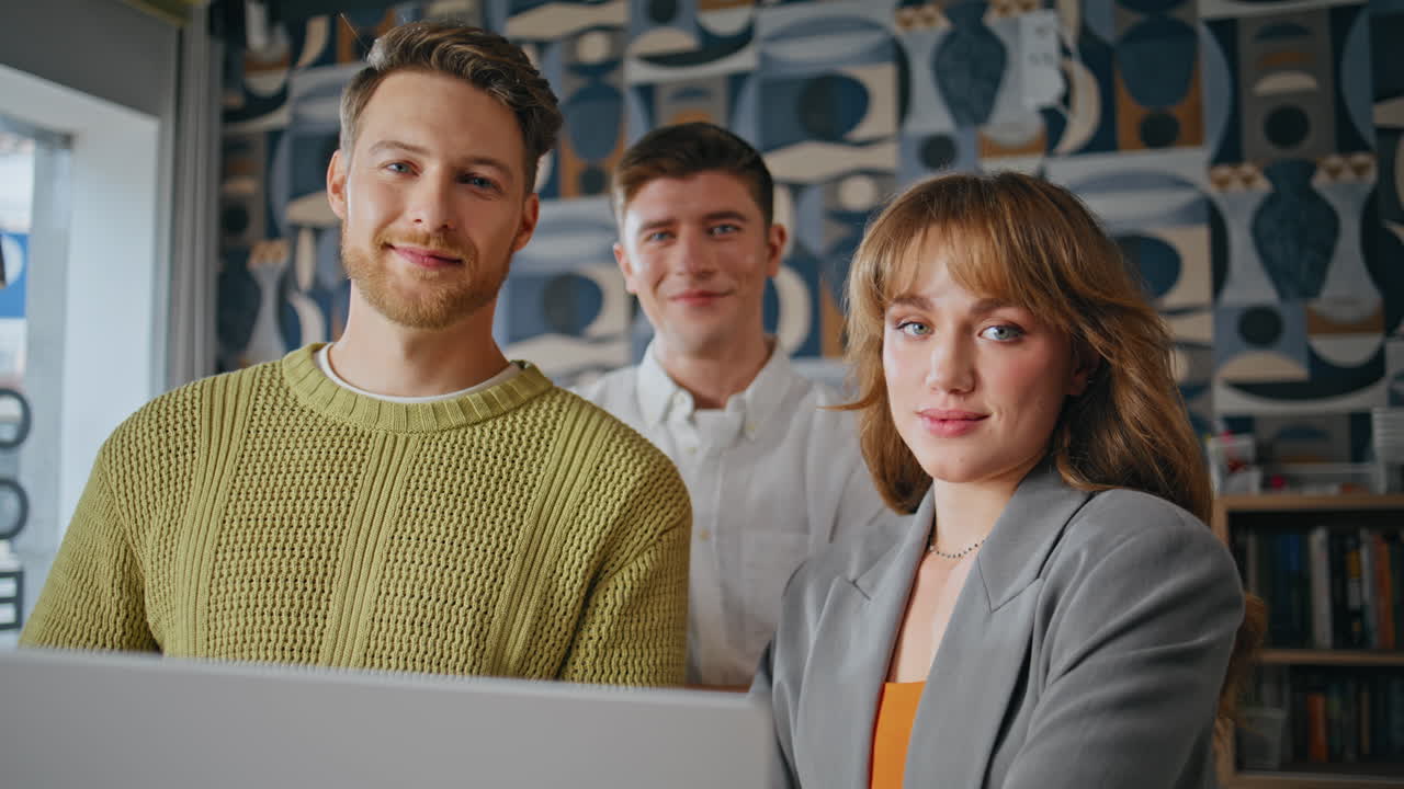 Startup-Team posiert für ein Porträt im Konferenzraum. Leute schauen auf den Laptop