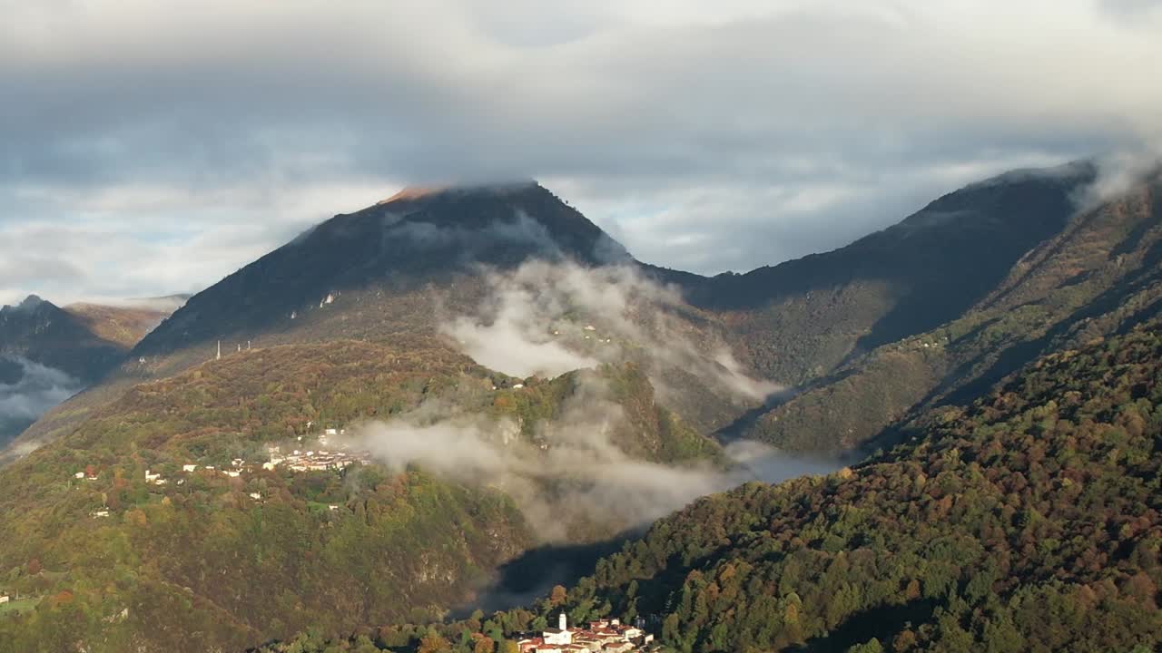 Scenic drone view over the Alps in Italy with misty mountain peaks