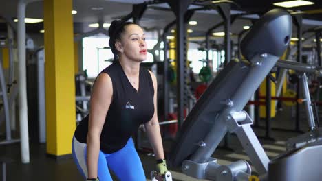 mujer levantando pesas en un gimnasio