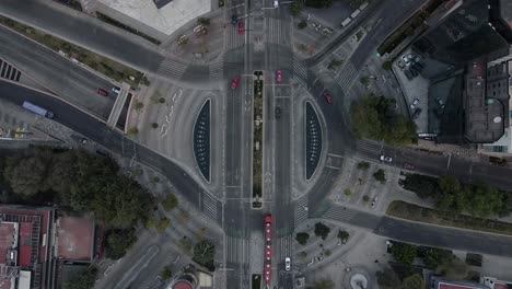 Aerial-closeup-viewof-a-roundabout-with-cars,-bicycles,-buses-and-people-walking-by