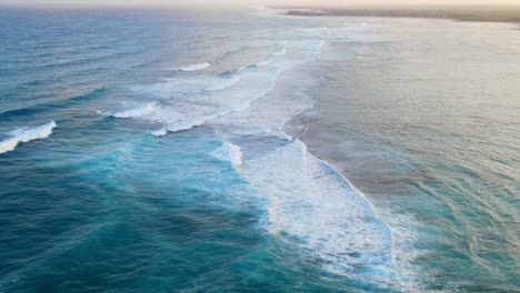 incredible waves at sunset reaching the seashore