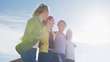 happy group of diverse female friends having fun, laughing at the beach