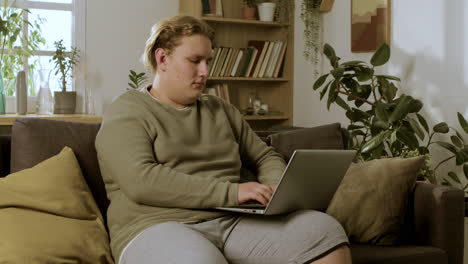 Young-blond-boy-sitting-on-the-sofa