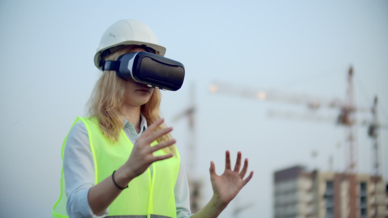 retrato de una operadora de grúa que opera un sitio de construcción usando gafas de realidad virtual mujer gerente de construcción gestiona el progreso y el plan de los edificios usando gestos al atardecer
