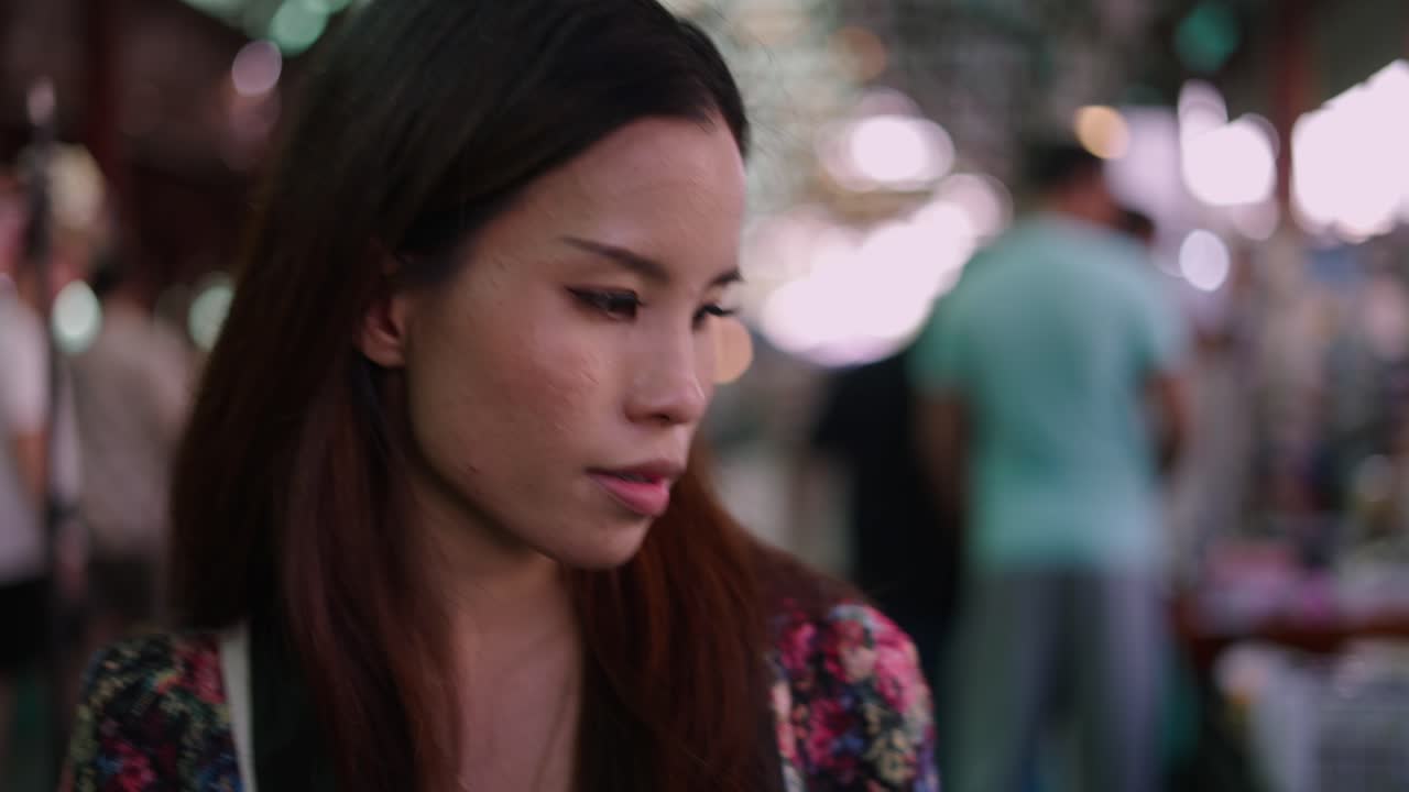 Young Asian Woman Holding a Drink in a Bustling Market