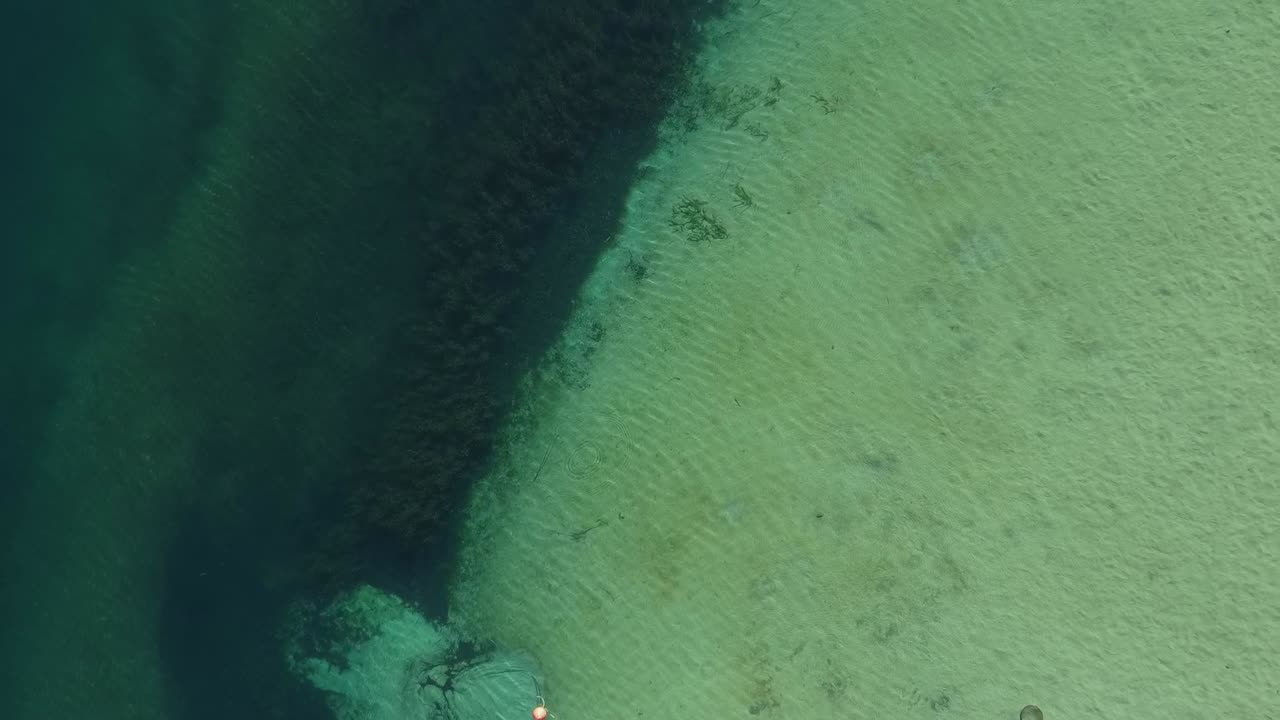 cenital shot of cristal clear lake with boat foalting and stunning lighting. captured in Patagonia Argentina