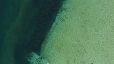 cenital shot of cristal clear lake with boat foalting and stunning lighting. captured in patagonia argentina
