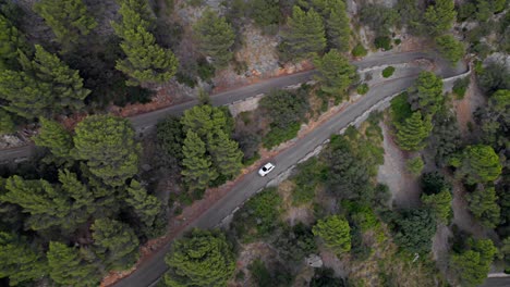 Car-drive-on-serpentine-road-to-port-de-valldemossa-town-at-Mallorca-spain-Drone-view