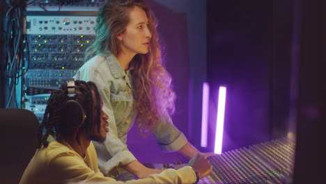 diverse man and woman speaking in sound recording studio