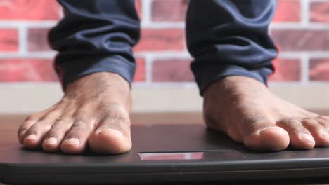 man weighing himself on a digital scale