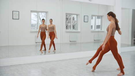 women practicing dance or yoga poses in a studio