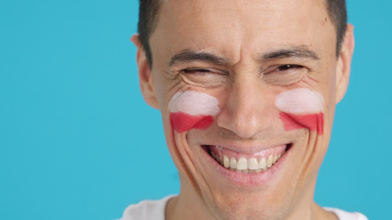 Man with a polish flag painted on the face smiling