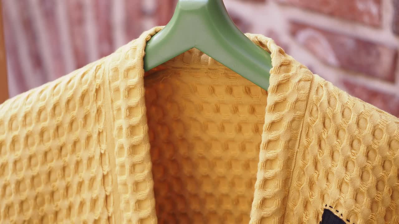 Yellow Waffle-Pattern Bathrobe Hanging on Hanger