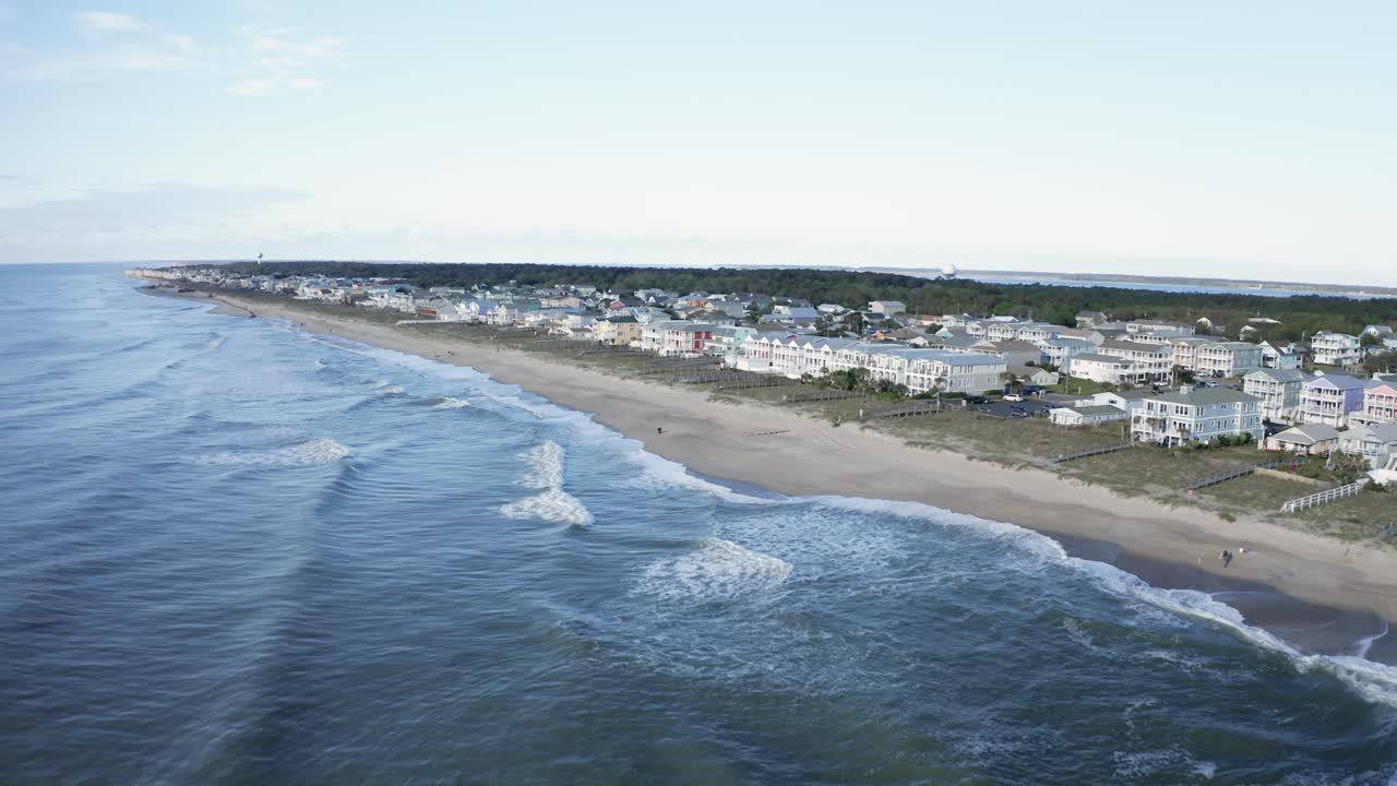 Drone che vola sull'oceano e si avvicina al litorale con case a Kure Beach, Carolina del Nord.