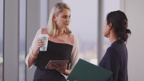 two professional businesswoman working together in modern office in slow motion