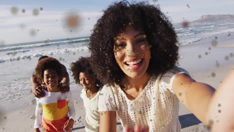on beach, family smiling with colorful animation particles floating around them