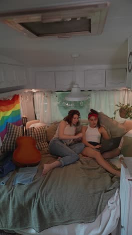 two women relaxing and working in a camper van