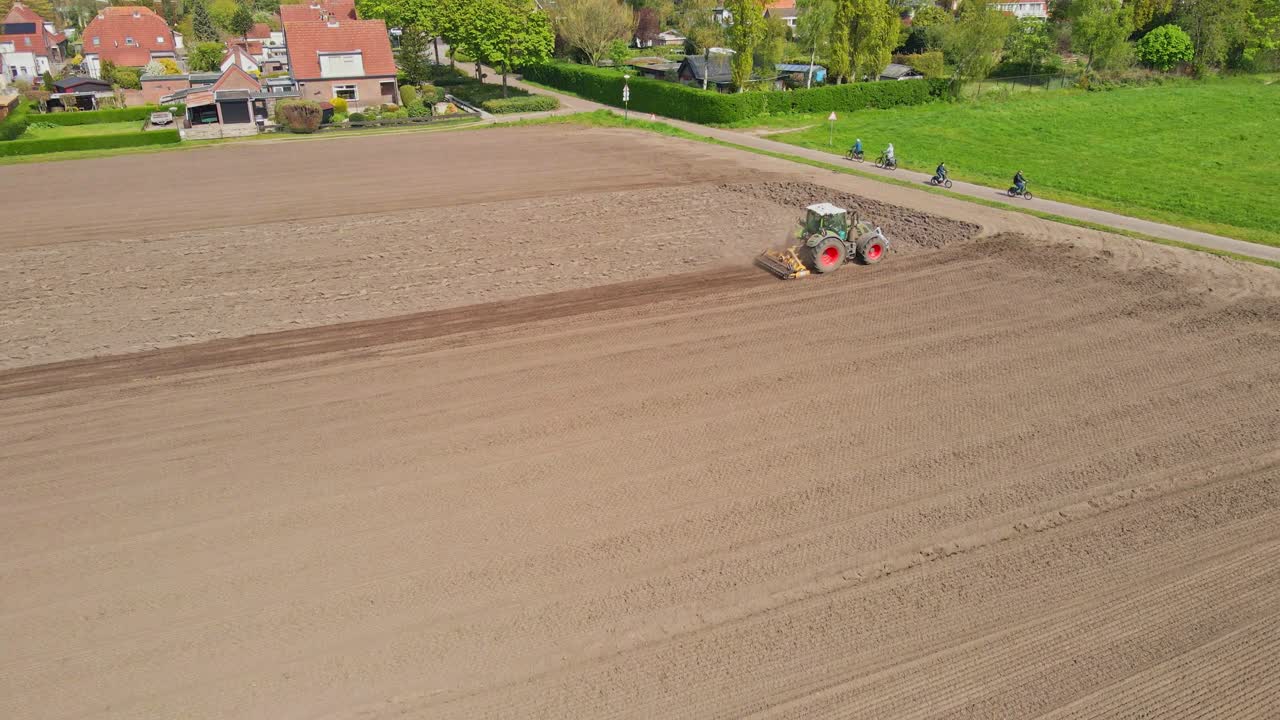 impresionante vista de ángulo alto de un tractor arando una parcela de tierra en los países bajos