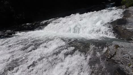 white foam from a very steep river in the swiss alps, in the mountains, rocky bed, wallis